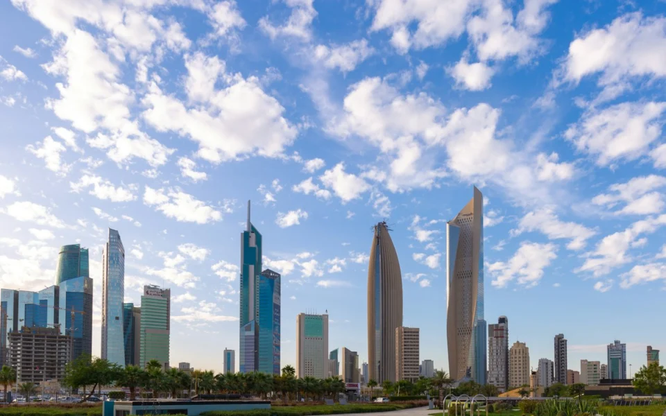 High-rise towers in Kuwait City under a blue sky